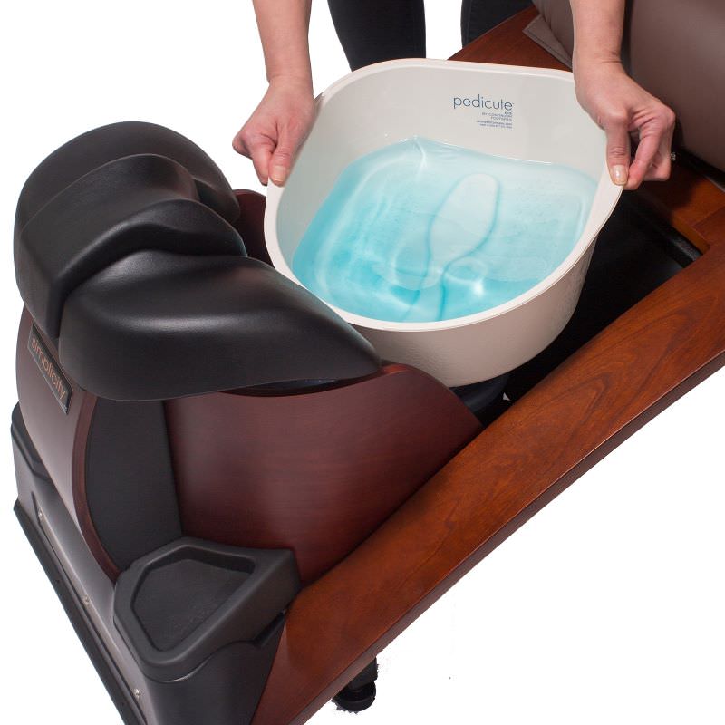 Foot spa with a pedicure bowl containing water on a wooden base of a pipeless pedicure chair