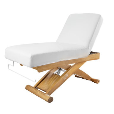 White massage table with wooden base on a black background