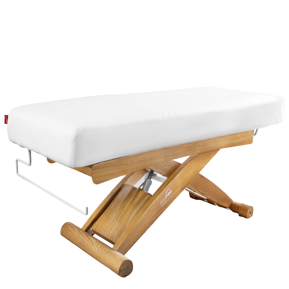 Wooden massage table with white cushion on a white background