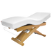 Massage table with white cushion and wooden frame on a black background